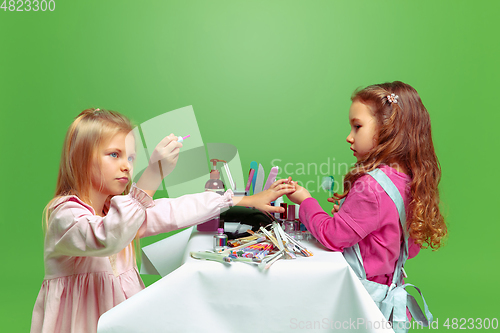 Image of Little girl dreaming about future profession of nails manicure artist
