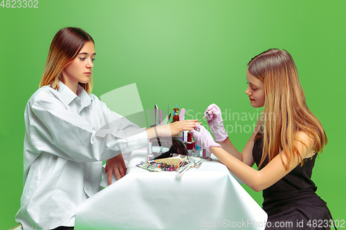 Image of Little girl dreaming about future profession of nails manicure artist