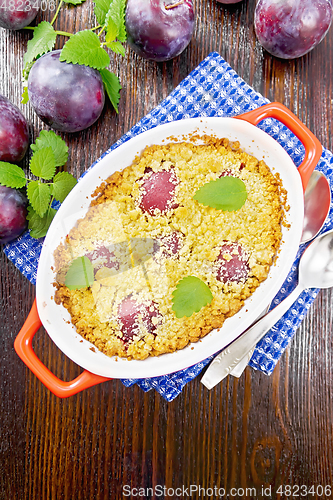 Image of Crumble with plum in brazier on dark board top