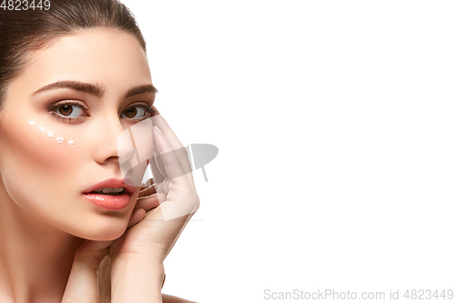 Image of girl applying moisturizing cream isolated on white