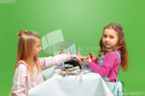 Image of Little girl dreaming about future profession of nails manicure artist