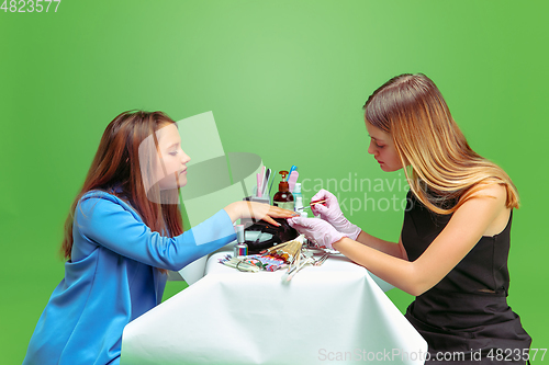 Image of Little girl dreaming about future profession of nails manicure artist