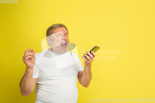 Image of Caucasian senior man\'s portrait isolated on yellow studio background