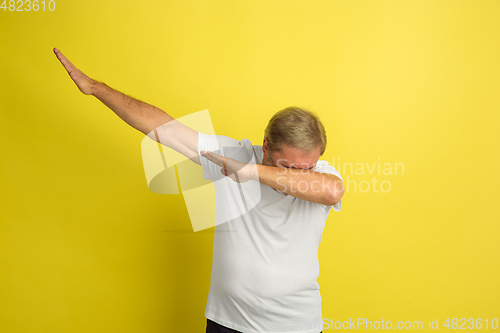 Image of Caucasian senior man\'s portrait isolated on yellow studio background