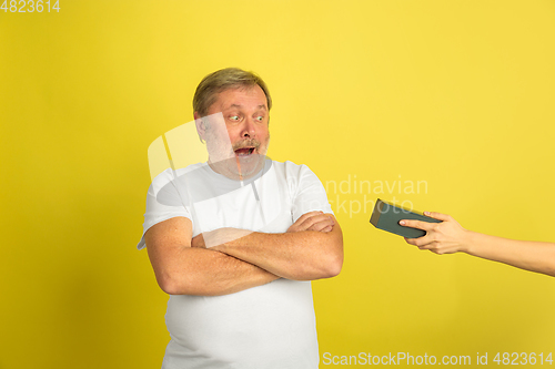 Image of Caucasian senior man\'s portrait isolated on yellow studio background