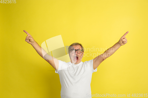 Image of Caucasian senior man\'s portrait isolated on yellow studio background