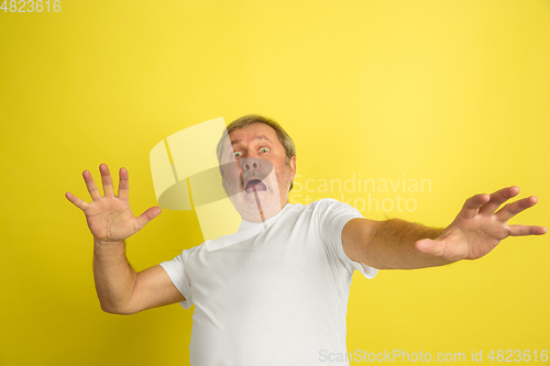 Image of Caucasian senior man\'s portrait isolated on yellow studio background