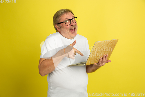 Image of Caucasian senior man\'s portrait isolated on yellow studio background