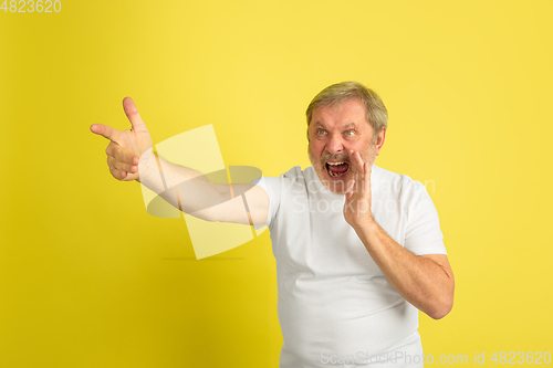 Image of Caucasian senior man\'s portrait isolated on yellow studio background
