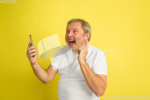 Image of Caucasian senior man\'s portrait isolated on yellow studio background