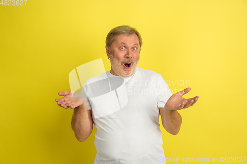 Image of Caucasian senior man\'s portrait isolated on yellow studio background