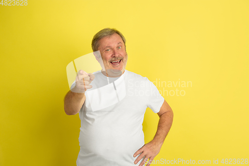 Image of Caucasian senior man\'s portrait isolated on yellow studio background