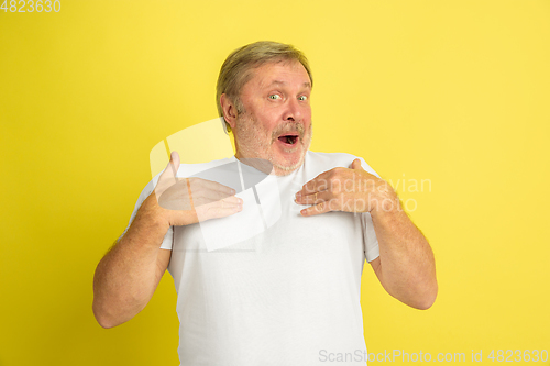 Image of Caucasian senior man\'s portrait isolated on yellow studio background