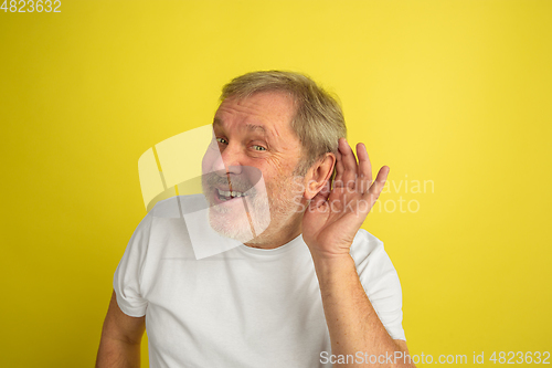 Image of Caucasian senior man\'s portrait isolated on yellow studio background