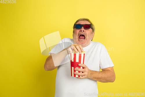 Image of Caucasian senior man\'s portrait isolated on yellow studio background