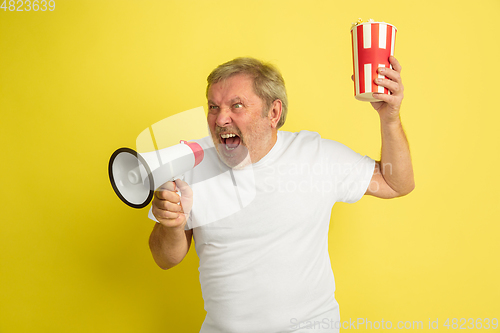 Image of Caucasian senior man\'s portrait isolated on yellow studio background