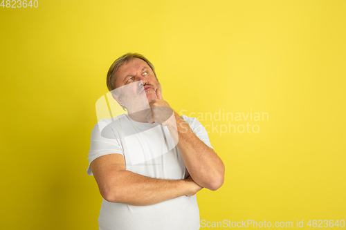 Image of Caucasian senior man\'s portrait isolated on yellow studio background