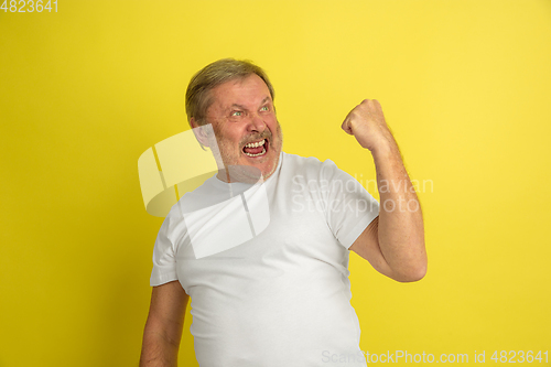 Image of Caucasian senior man\'s portrait isolated on yellow studio background