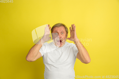 Image of Caucasian senior man\'s portrait isolated on yellow studio background