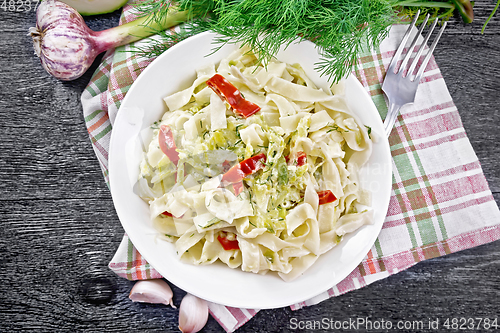 Image of Fettuccine with zucchini and hot peppers in plate on board top
