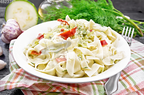 Image of Fettuccine with zucchini and hot peppers in plate on dark board