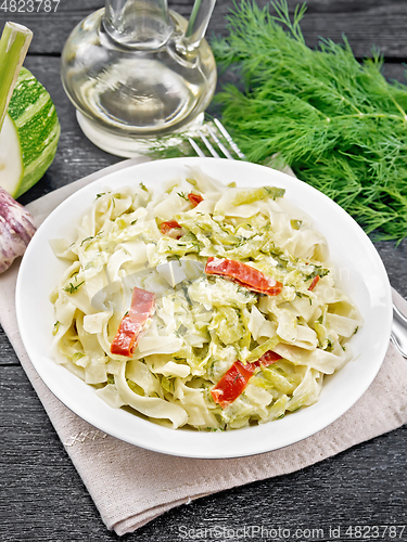 Image of Fettuccine with zucchini and hot peppers in plate on towel