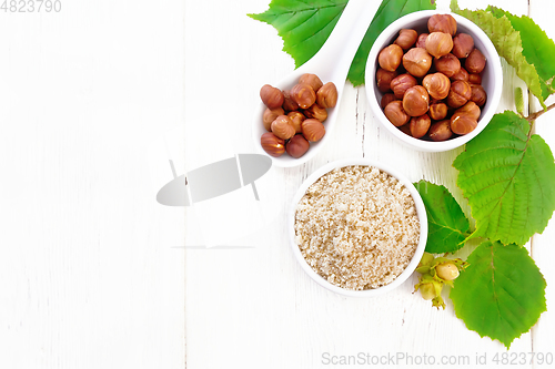 Image of Flour and hazelnuts in bowls on board top