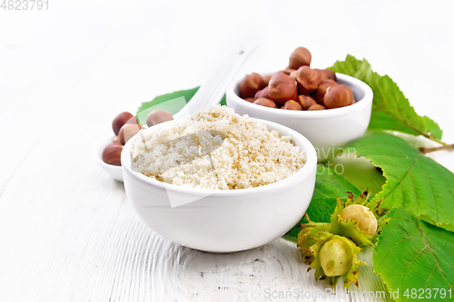 Image of Flour and hazelnuts in bowls on white board