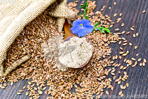 Image of Flour flax in spoon with seeds and flower on board