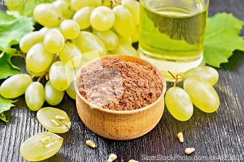 Image of Flour grape seed in bowl on black wooden board