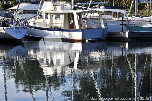 Image of Moored sailboats reflecting in water