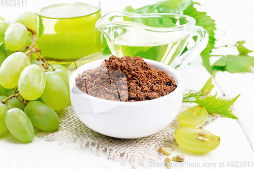 Image of Flour grape seed in bowl on light wooden board