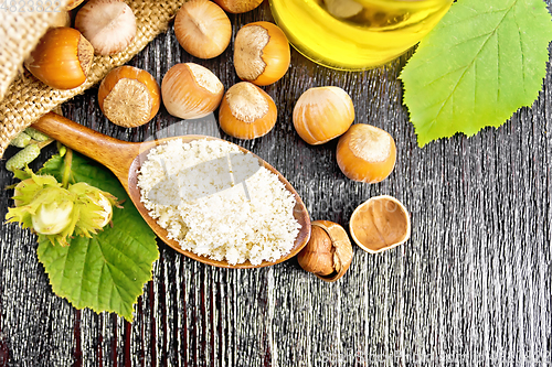 Image of Flour in spoon with nuts on board top