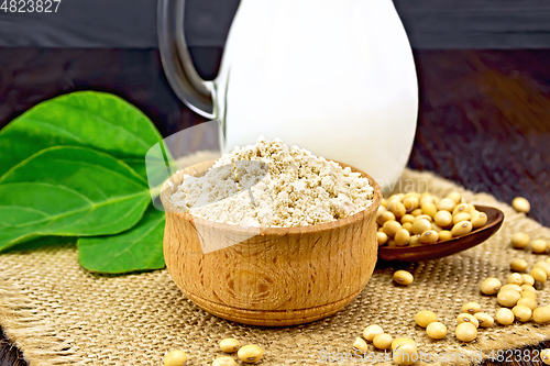 Image of Flour soy in bowl with milk and soybeans on dark board