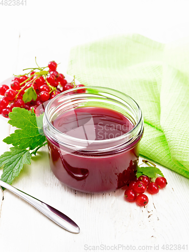 Image of Jam of red currant in jar on wooden board