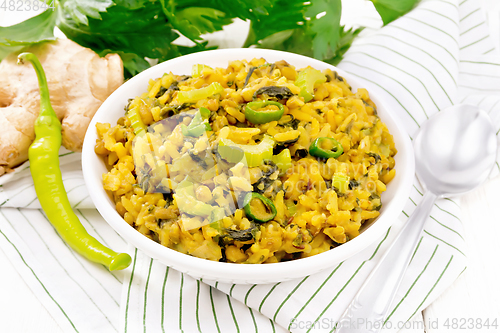 Image of Kitchari with celery in bowl on board