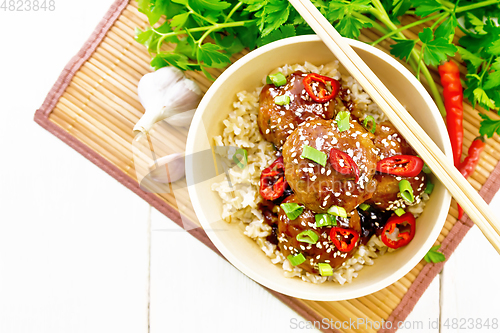 Image of Meatballs in sweet and sour sauce with rice on board top