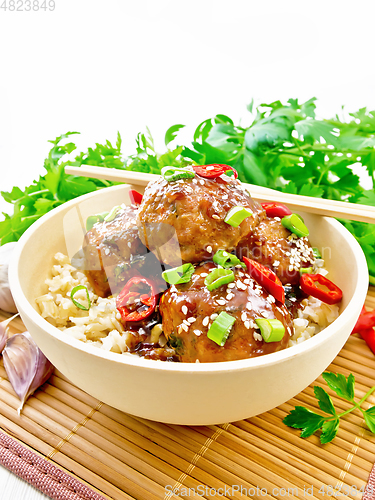 Image of Meatballs in sweet and sour sauce with rice on board