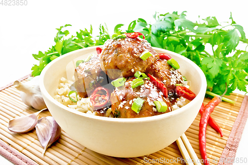 Image of Meatballs in sweet and sour sauce with rice on wooden board