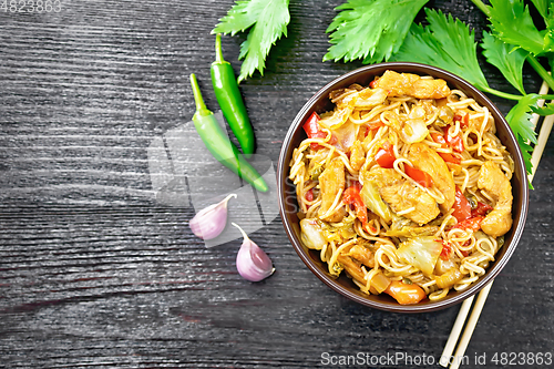 Image of Noodles with cabbage and chicken in bowl on dark board top