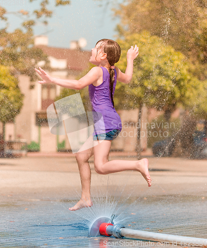 Image of Girl is enjoying fountain with cold water