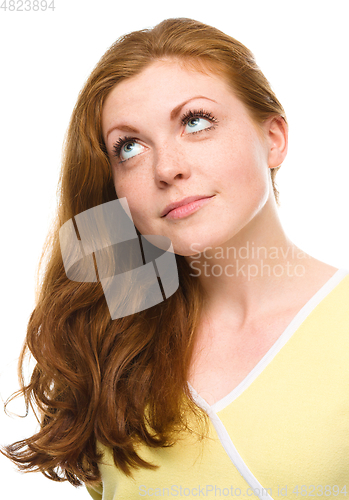 Image of Young happy woman is looking up and smile