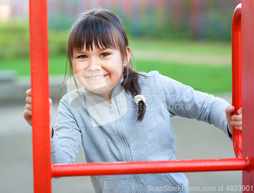 Image of Cute little girl is playing in playground