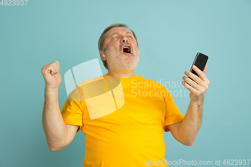 Image of Caucasian senior man\'s portrait isolated on blue studio background