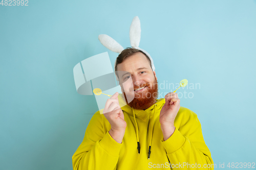 Image of Easter bunny man with bright emotions on blue studio background