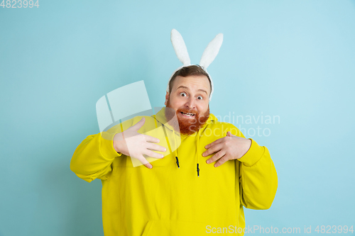 Image of Easter bunny man with bright emotions on blue studio background