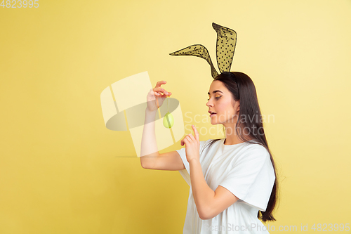 Image of Easter bunny woman with bright emotions on yellow studio background