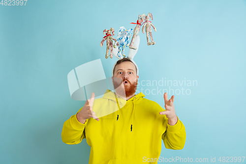 Image of Easter bunny man with bright emotions on blue studio background