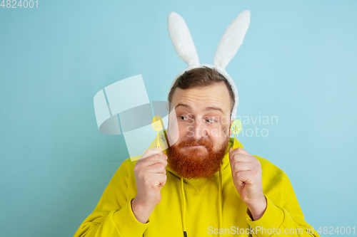 Image of Easter bunny man with bright emotions on blue studio background