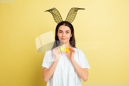 Image of Easter bunny woman with bright emotions on yellow studio background